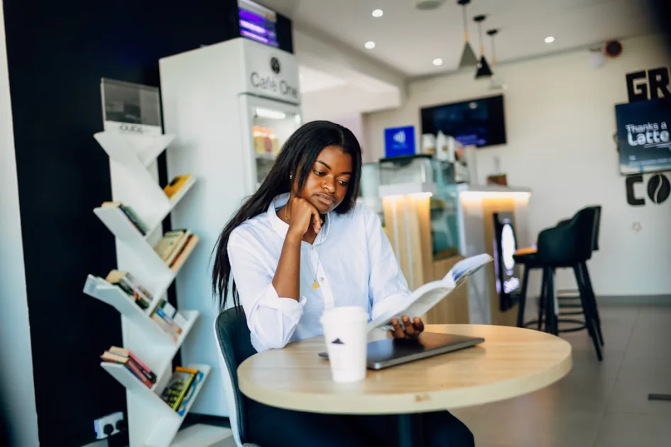 A woman sitting at a table using a laptop computer