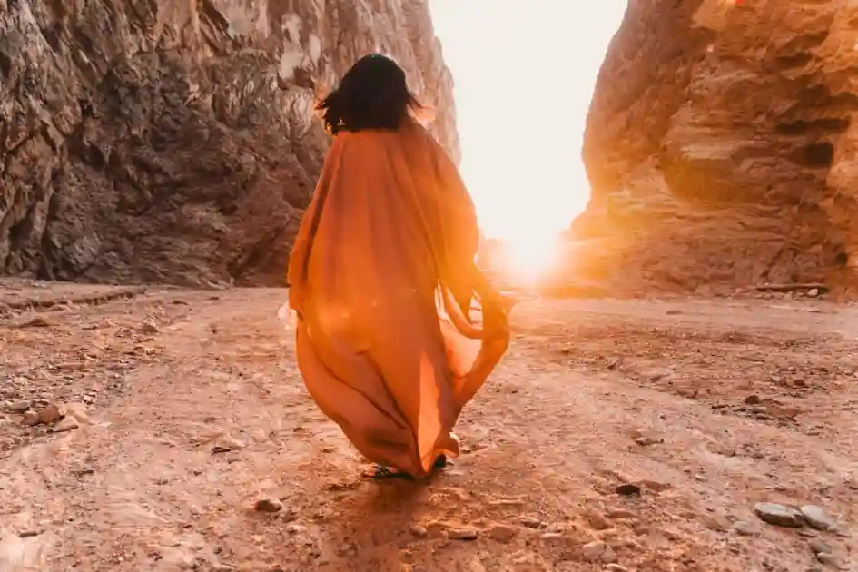 A woman walking through a canyon, symbolizing the journey to automate spiritual business while preserving human essence