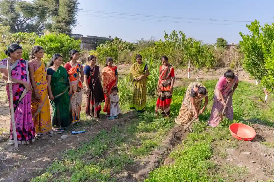 a group of women standing next to each other in a field