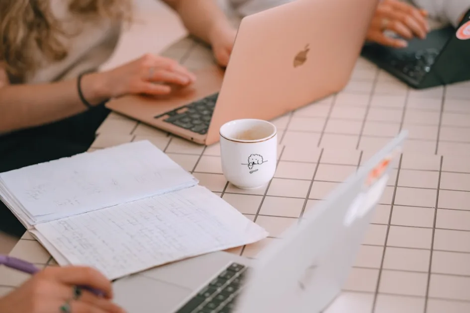 People working on laptops with notebooks and notebooks