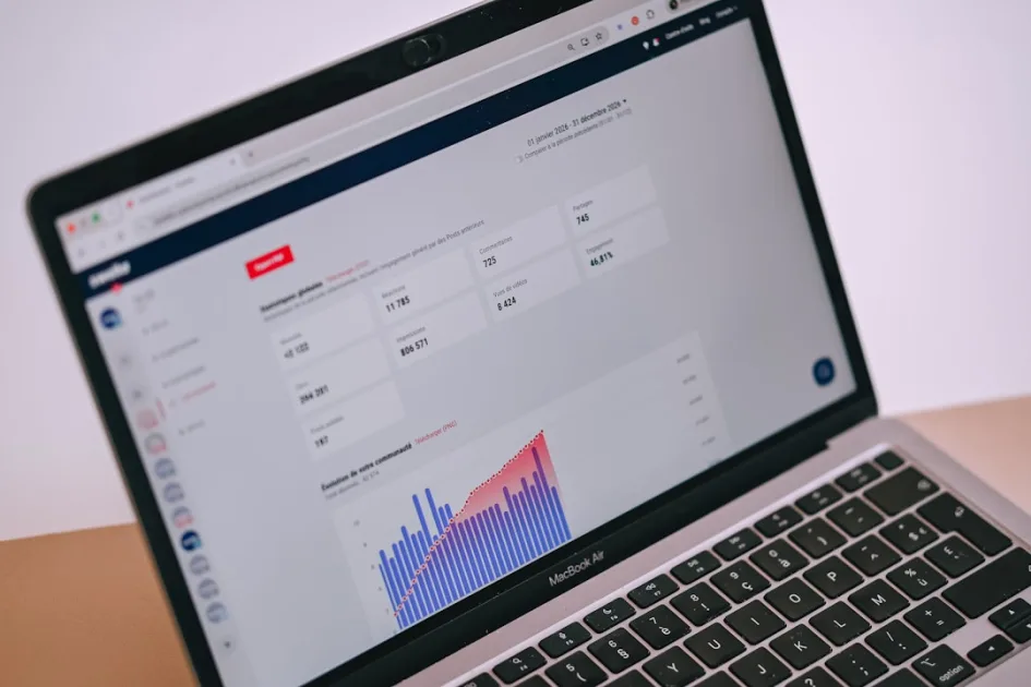 A laptop screen displays data analytics, charts, and statistics.